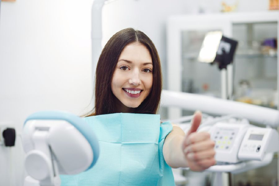 Woman showing thumbs up at a reception at the dentist