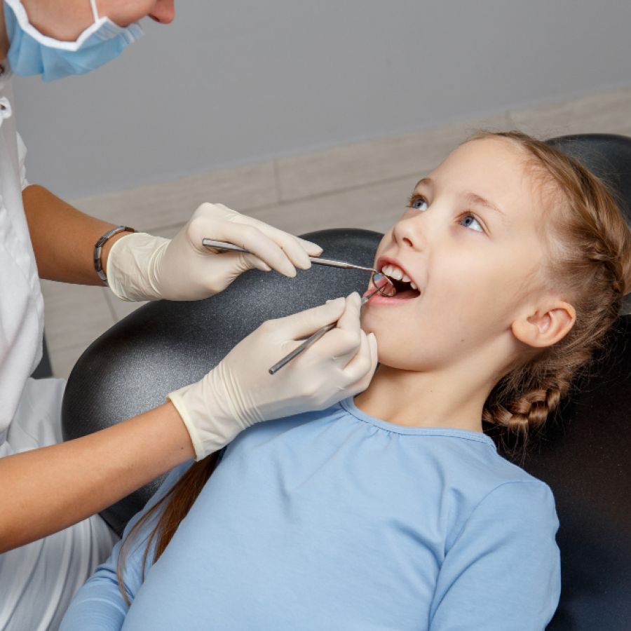 Child having dental check up by specialist in dentist office