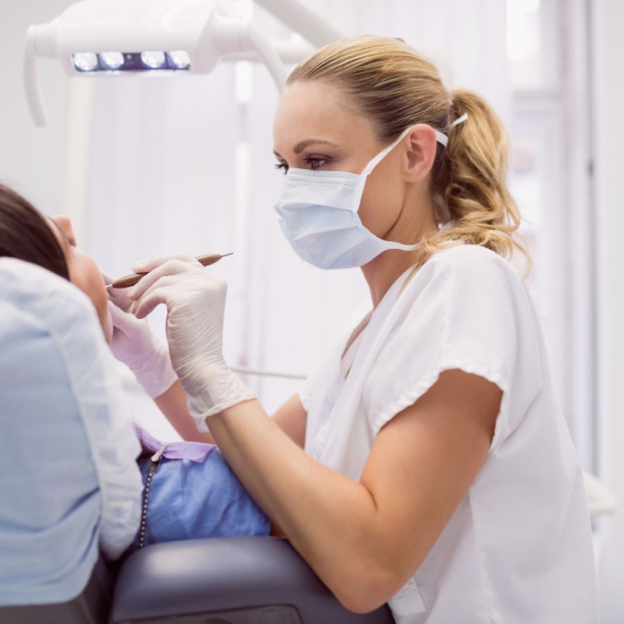 Dentist examining female patient