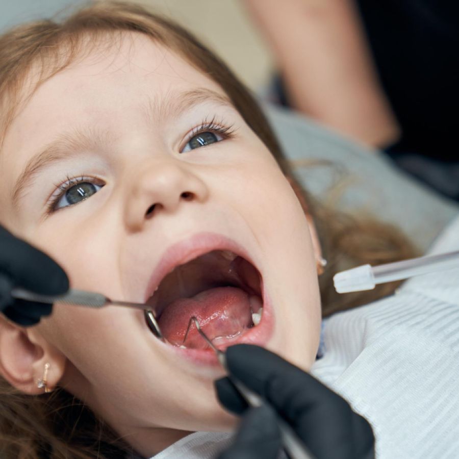 Dentist examining condition of teeth of little patient